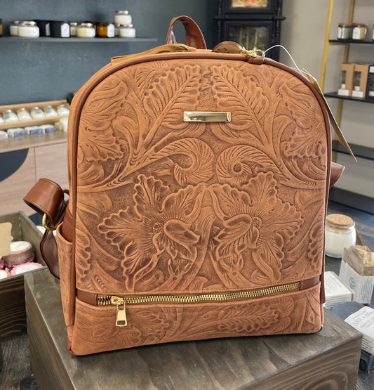 Brown embossed backpack on a wooden block in a store setting