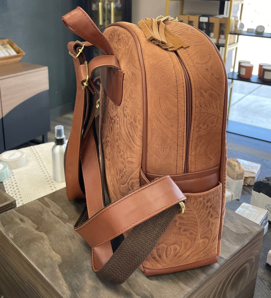 Brown leather backpack on a wooden surface with a store interior in the background